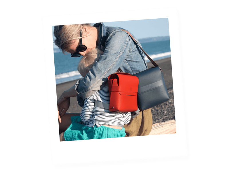 mother and daughter with blue shoulder bag and red backpack